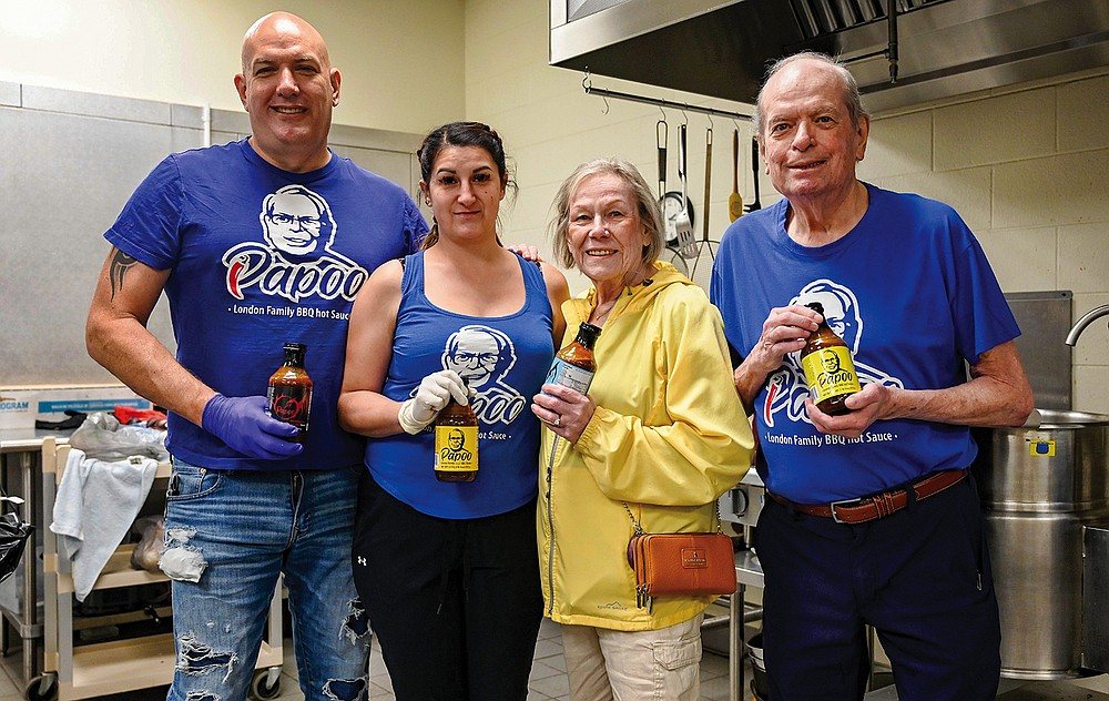 The London family in Papoo's shirts holding bottles of Papoo's BBQ Sauce