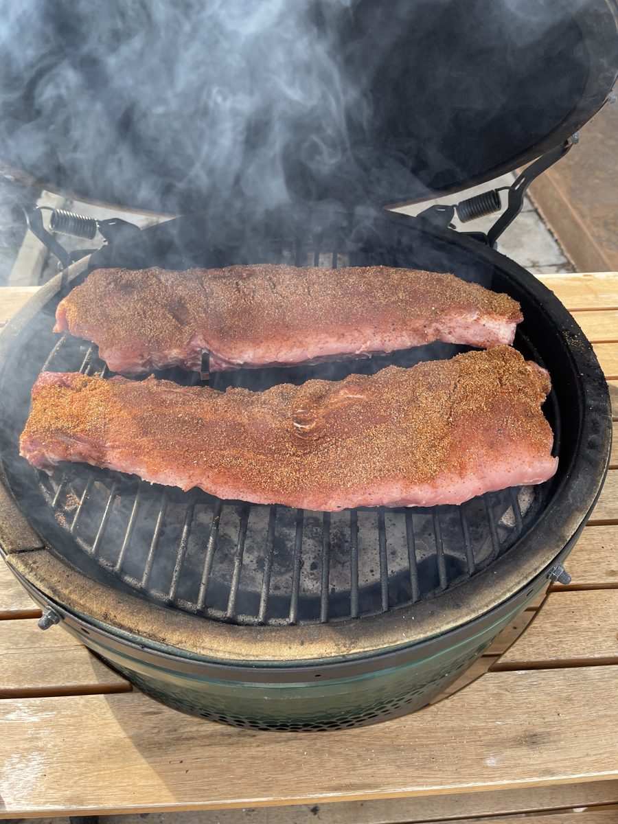 Two racks of ribs with rub on the smoker