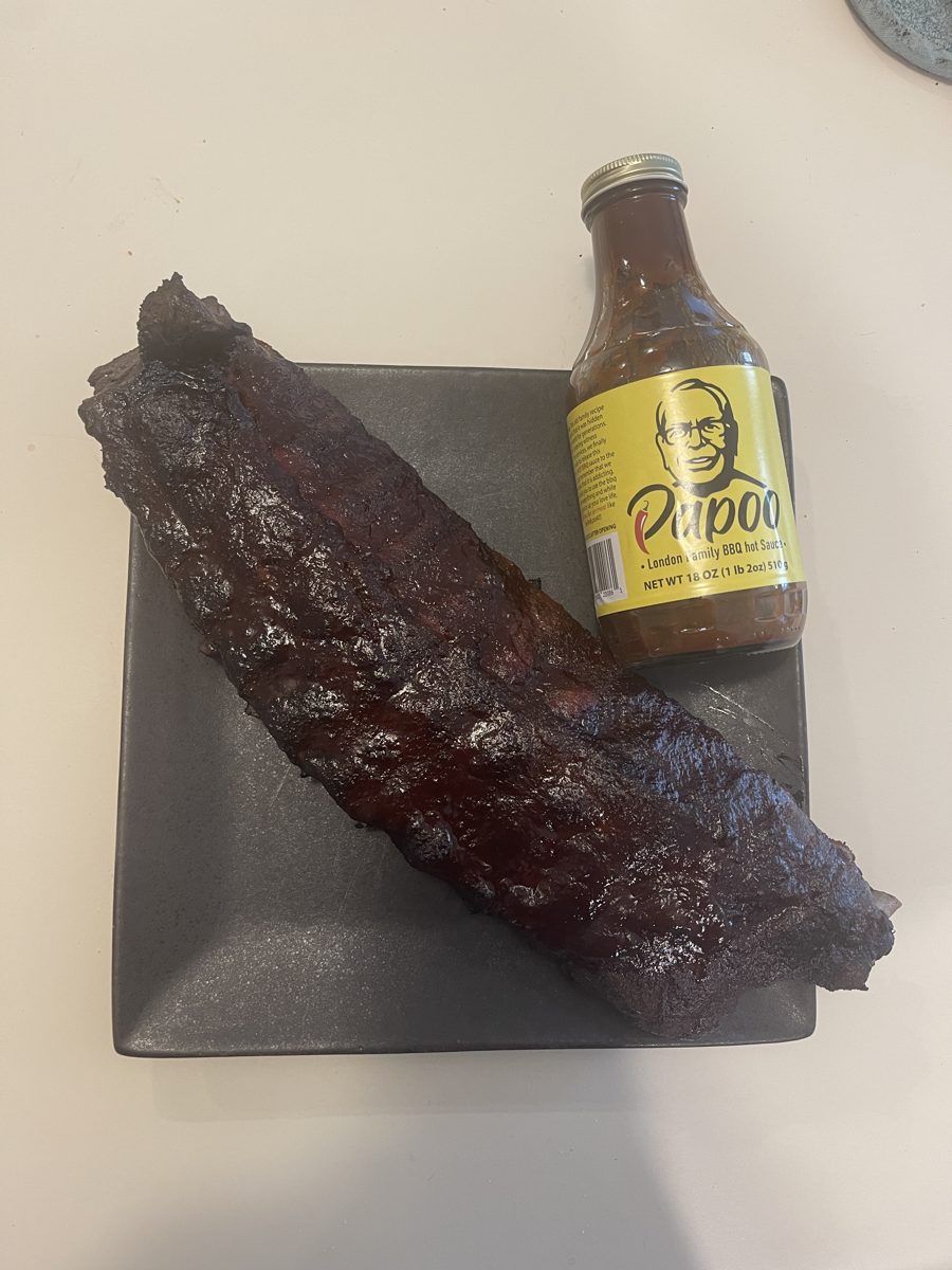 Smoked baby back ribs next to a bottle of Papoo's Original